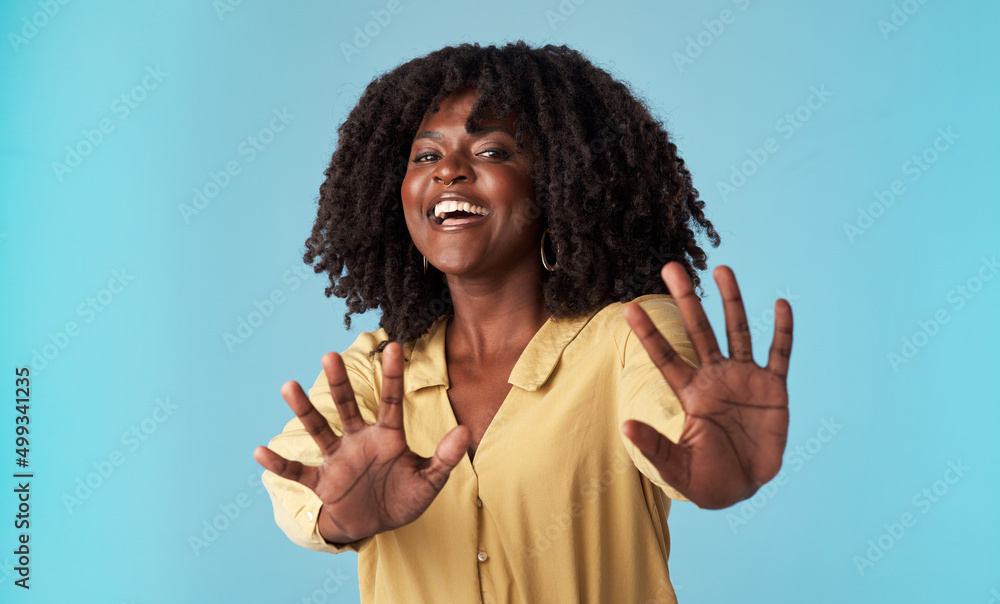 Woah Too much information. Studio shot of an attractive young woman holding out her arms against a b