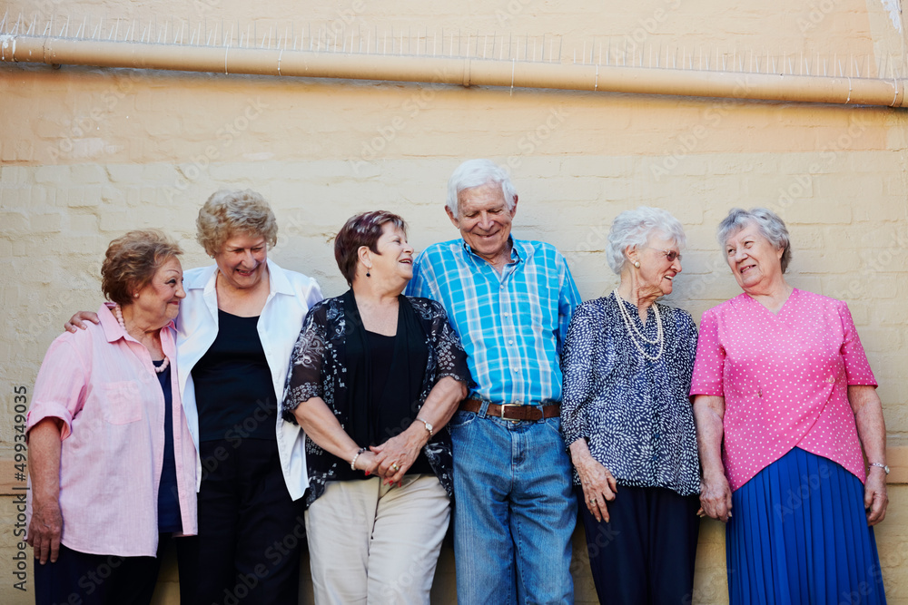 The older we get, the more we enjoy life. Shot of a group of seniors standing against a wall outside