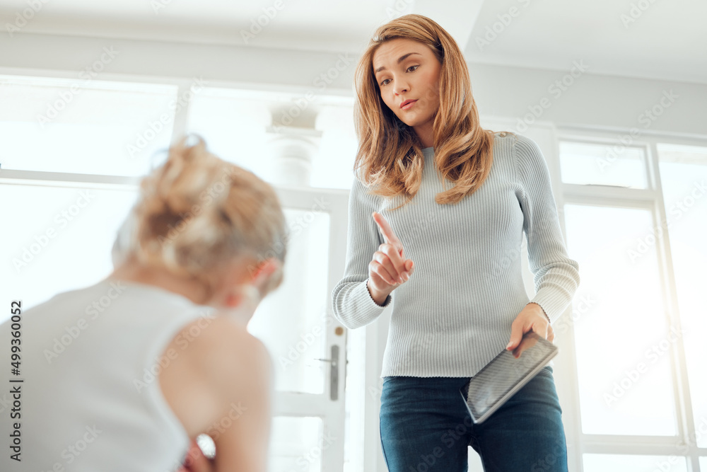 No more screen time for you. Shot of a mother fed up with her daughters bickering about a digital ta