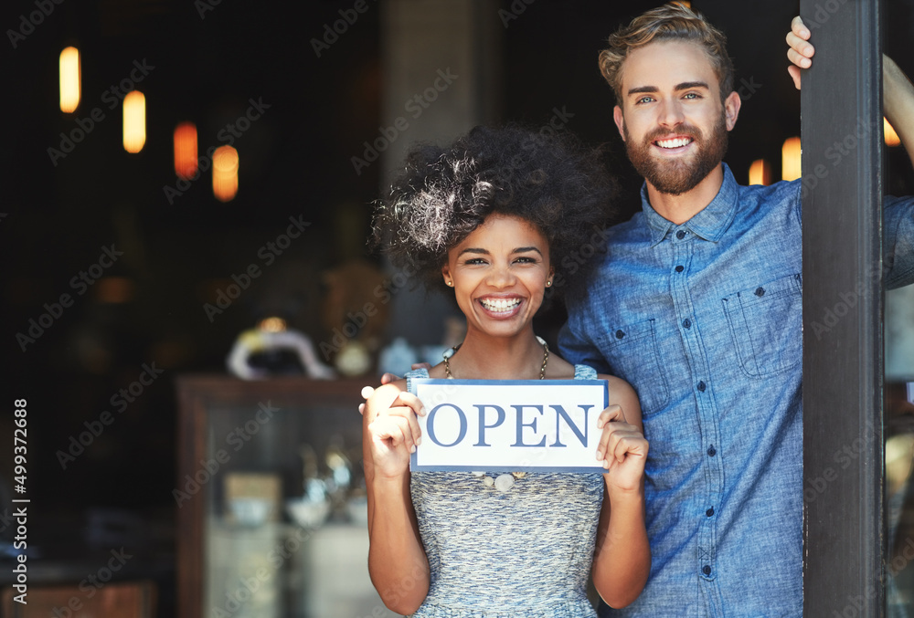 Youll love the service we have to offer. Portrait of two proud coffee shop owners holding up a sign 