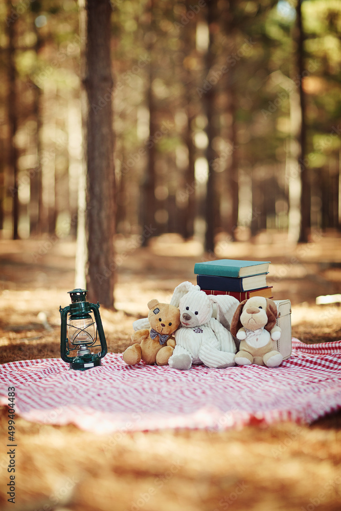 Its time for a picnic in the park. Shot of teddybears sitting on a picnic blanket in the woods.