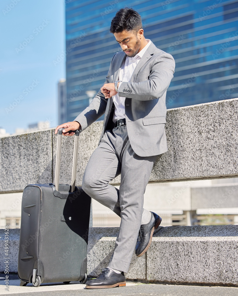 I hope Im not going to be late. Shot of a young businessman checking the time while standing with a 