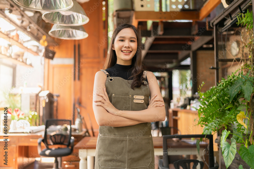 portrait of asian adult female woman wear apron standing at entrance of her workshop pottery studio 