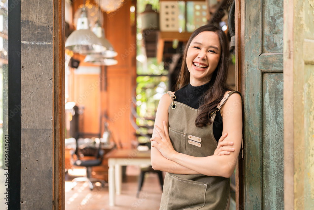 portrait of asian adult female woman wear apron standing at entrance of her workshop pottery studio 