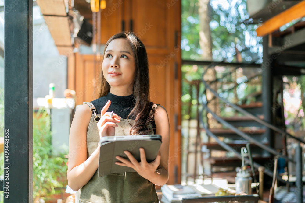 亚洲女性成人创意设计师快乐思考工作和研究并记录兴趣