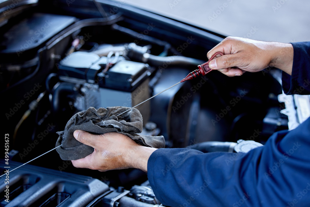 Checking your oil. High angle shot of an unrecognizable male mechanic working on the engine of a car