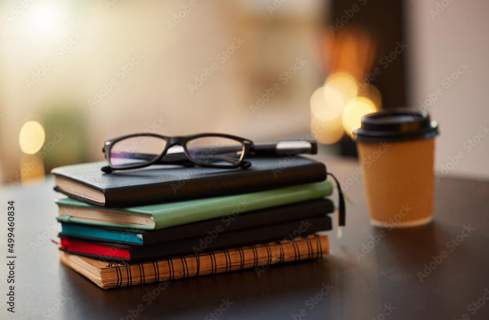 Knowledge is power. Shot of a stack of books on a table in a office.