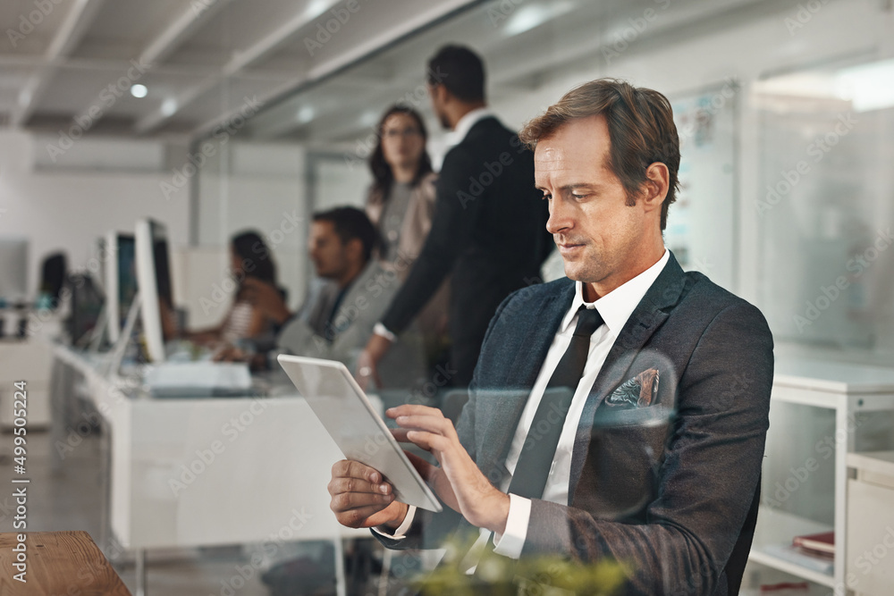 The game is changing. Cropped shot of a handsome mature businessman working on his tablet in the off