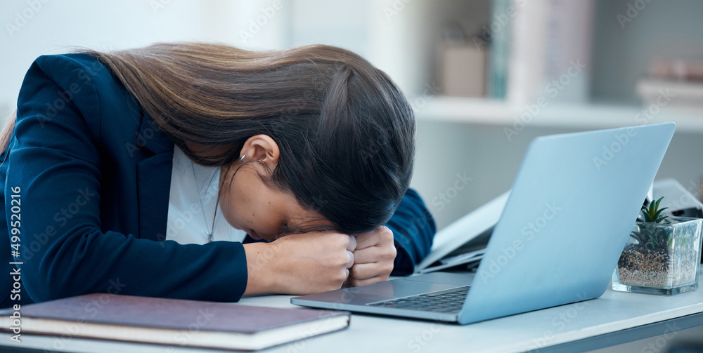 I cant get anything done right today. Shot of a young businesswoman sleeping at her desk in an offic