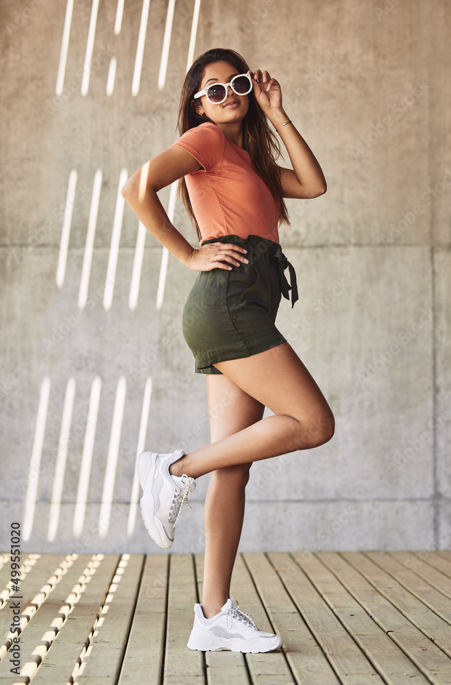 My time now, my world, my life. Shot of an attractive young woman wearing sunglasses posing against 