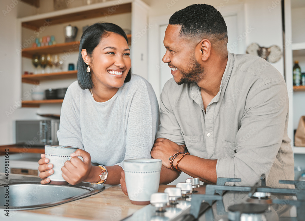 Chit-chats over a lovely cuppa. Shot of a young couple drinking coffee together in the kitchen at ho