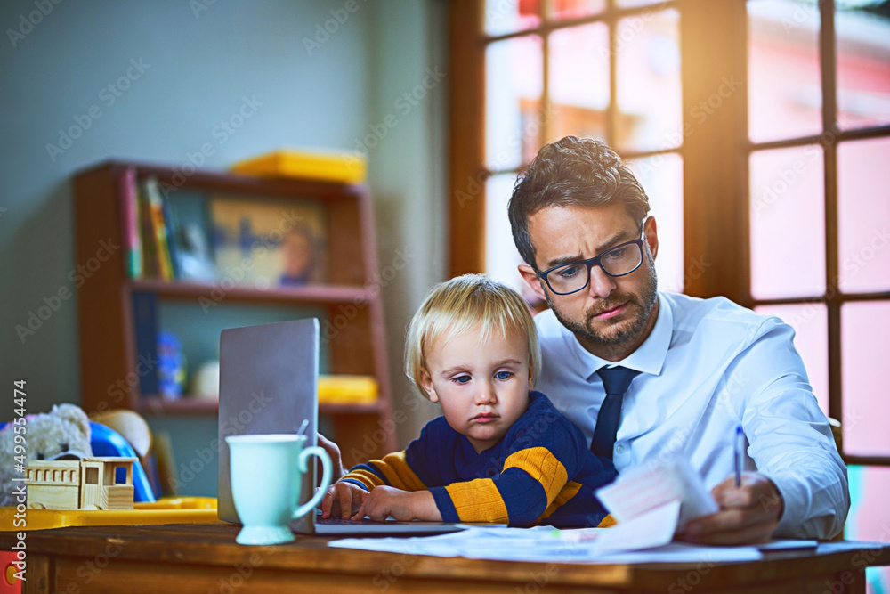 He handles his baby and business at the same time. Shot of a single father going through paperwork a