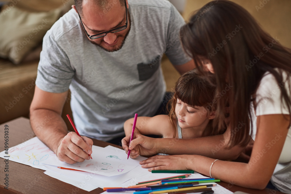 They encourage creative play in their home. Shot of a mother and father drawing together with their 