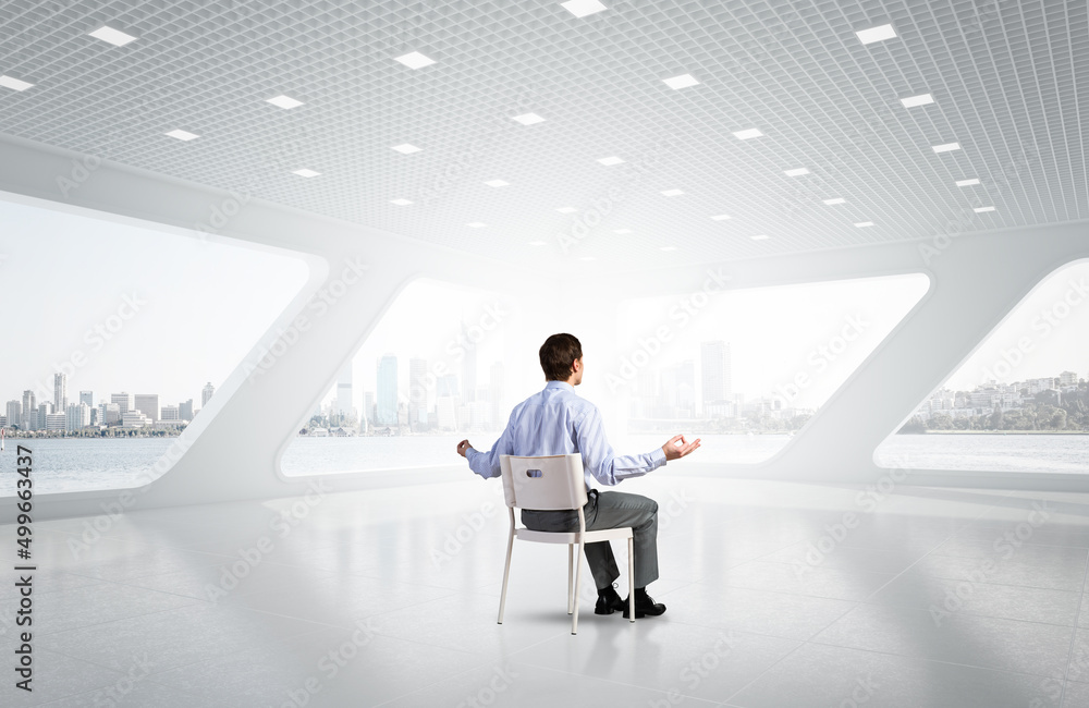 young businessman meditating in the office