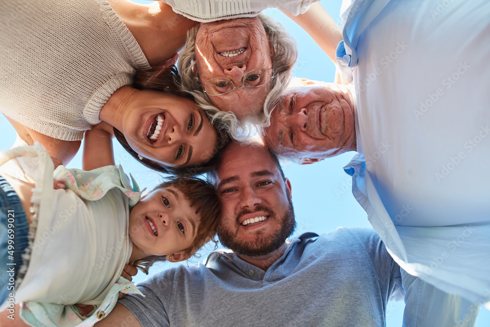 Family, the center of life. Low angle portrait of a happy three generation family huddled together o