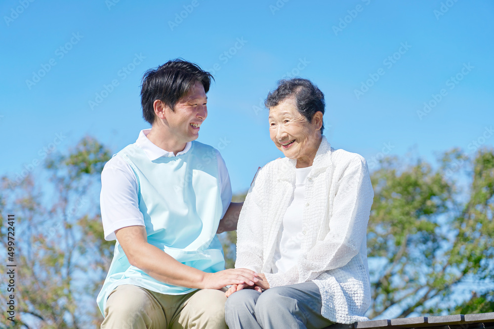 介護士と高齢者　屋外