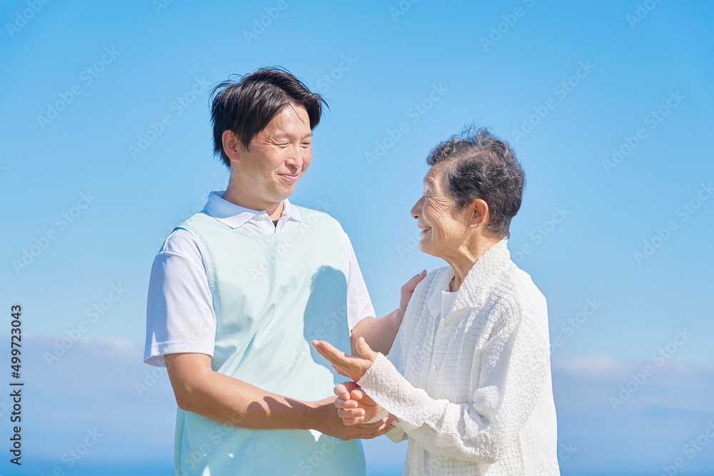 介護士と高齢者　屋外