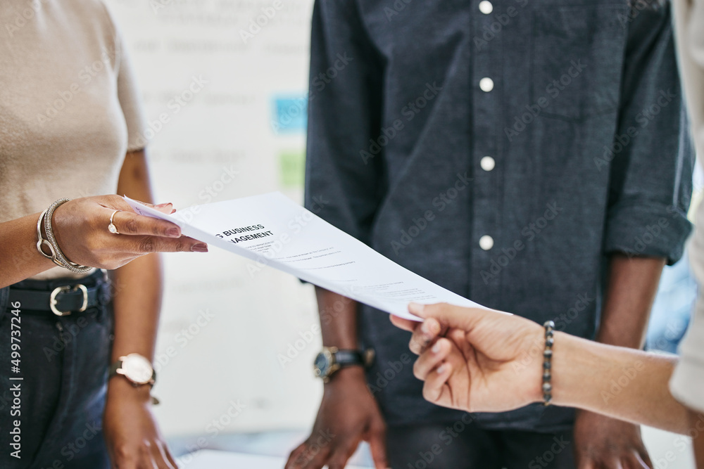 Please sign on the dotted line. Shot of businesspeople transferring documents.