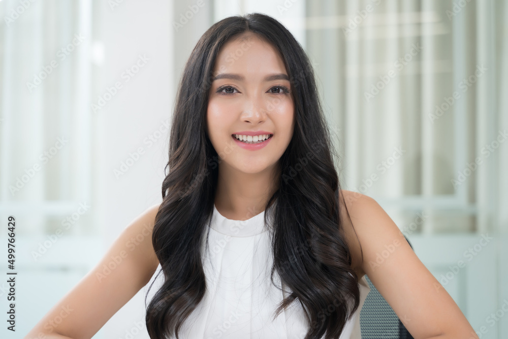 Close up portrait young Asian woman smiling in office