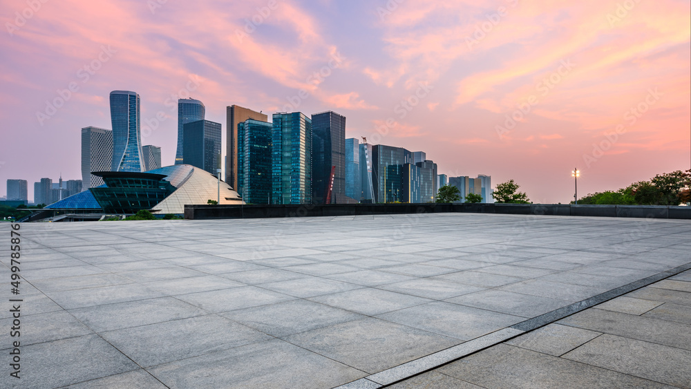 日出时，中国杭州，空旷的广场层和城市天际线，现代商业建筑。