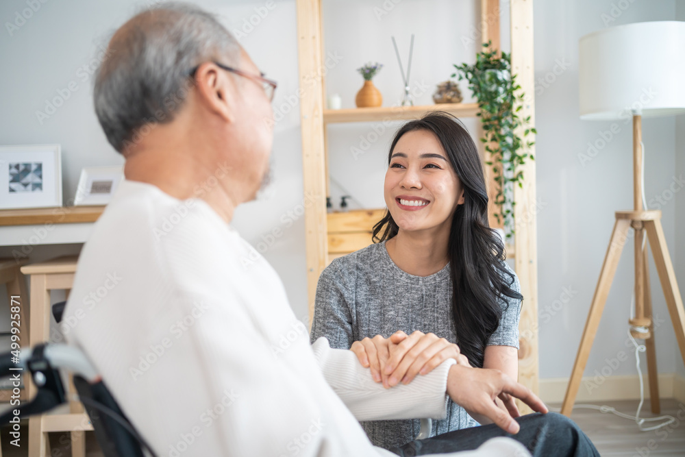 亚洲女儿支持家里坐在轮椅上的残疾老人。