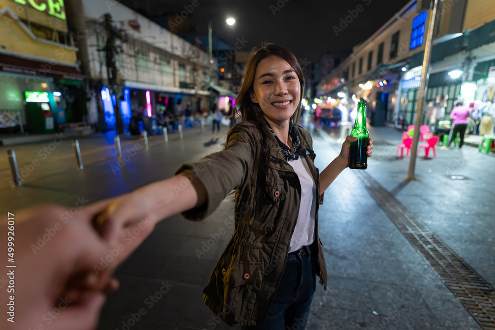 亚洲女旅行者的肖像，牵着男朋友的手，走在街上