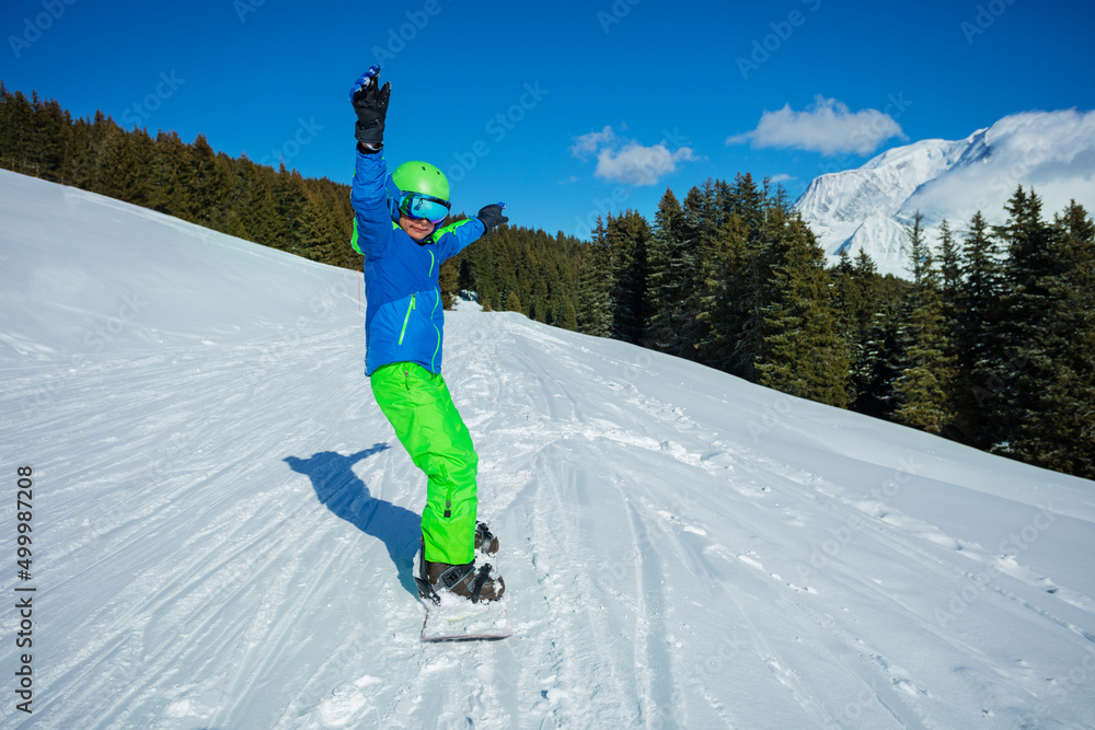 男孩从山上快速滑上滑雪板，正面视图