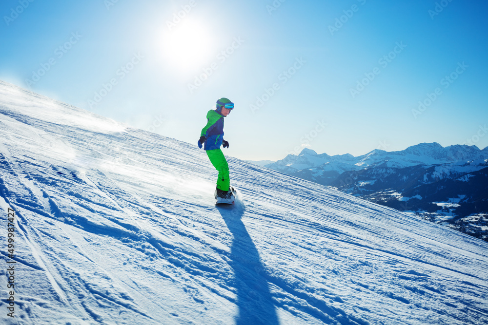 滑雪板男孩在高山滑雪坡滑雪板上下坡