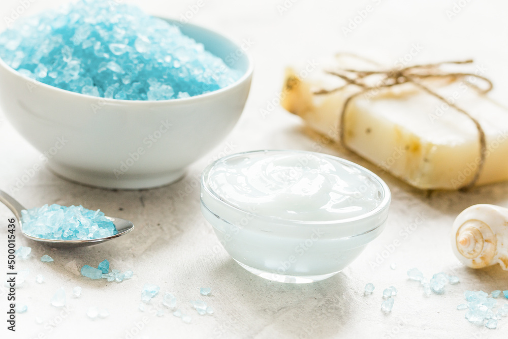 set for bath with blue salt and shells on stone table background