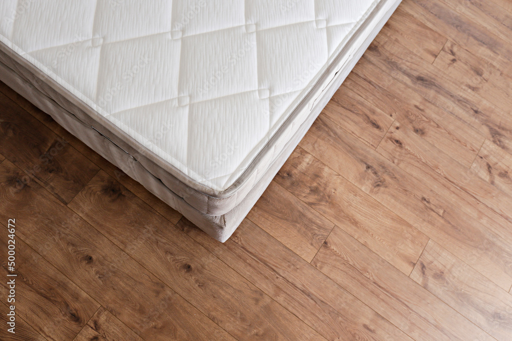 White orthopedic mattress top side surface pattern on unmade bed in the bedroom. Hypoallergenic foam