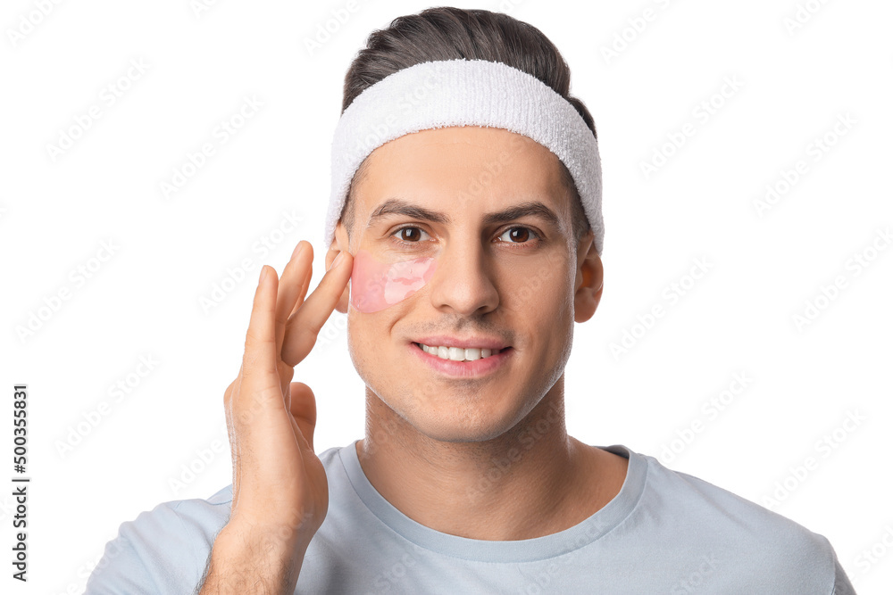 Handsome man with under-eye patches on white background