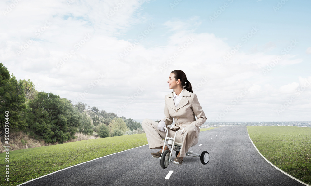 Beautiful young woman riding childrens bicycle