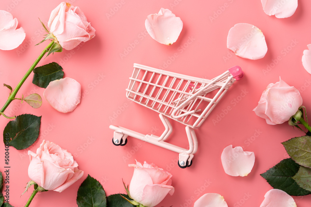 Mothers Day shopping design concept background with pink rose flower and cart on pink background.