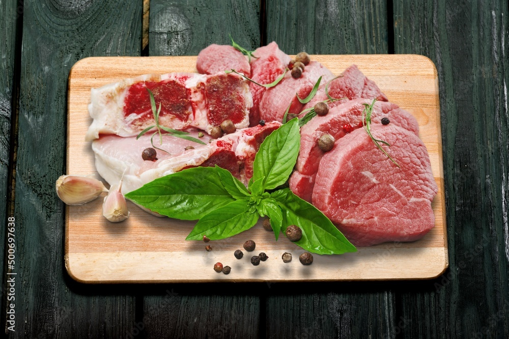 Fresh raw meat on board with ingredients for marinated