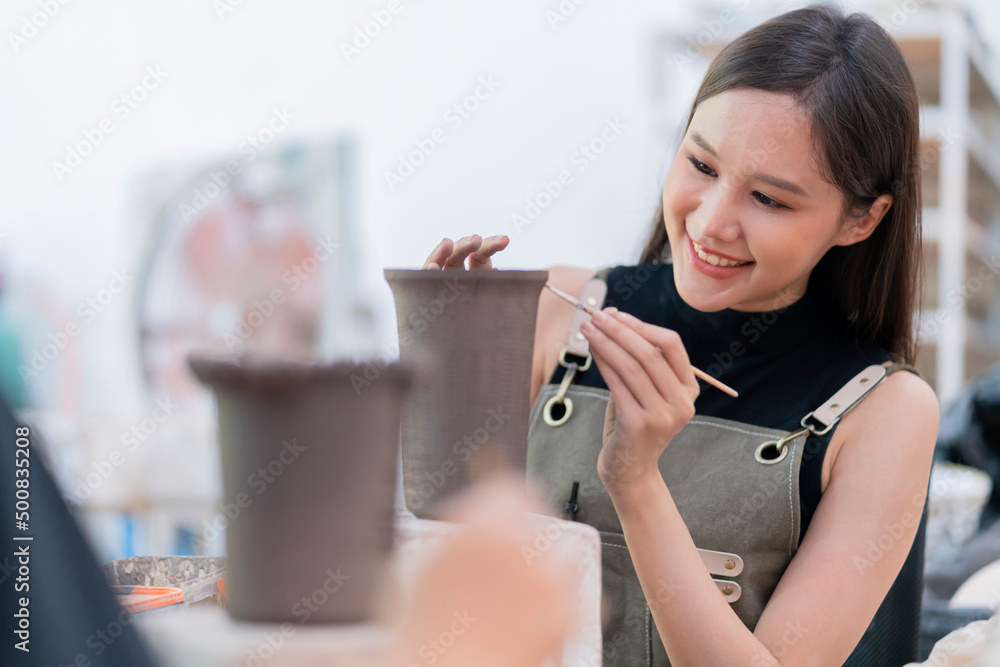 女性手在陶轮上作画的特写，亚洲女性雕塑女性涂色小