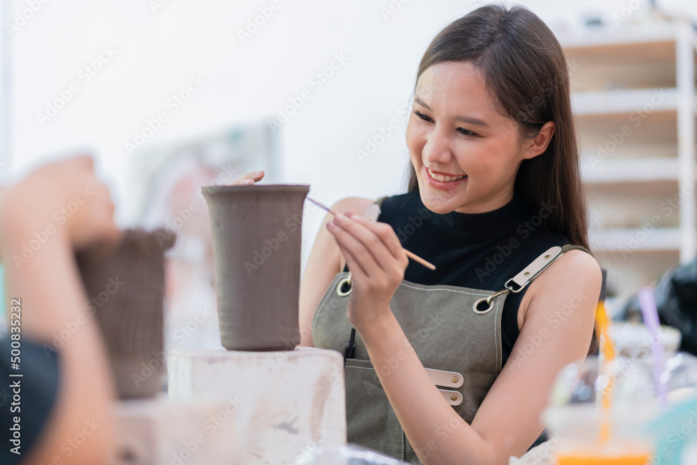 女性手在陶轮上作画的特写，亚洲女性雕塑女性涂色小