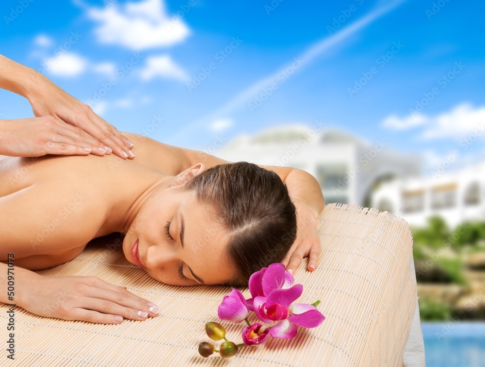 Beauty and relaxation concept - beautiful young woman on massage at spa over tropical beach backgrou