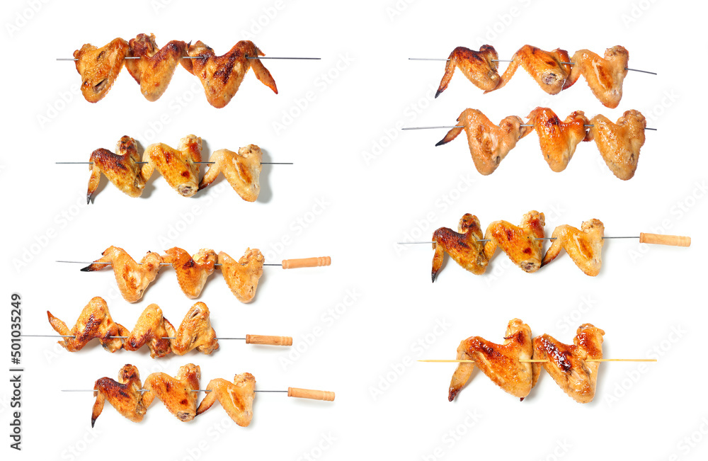 Set of skewers with tasty grilled chicken wings isolated on white