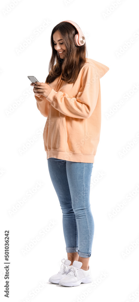 Beautiful young woman in stylish hoodie listening to music on white background