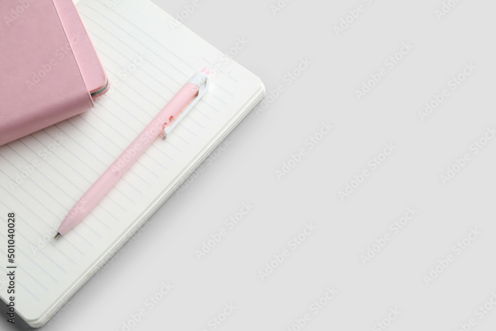 Notebooks and pen on light  background