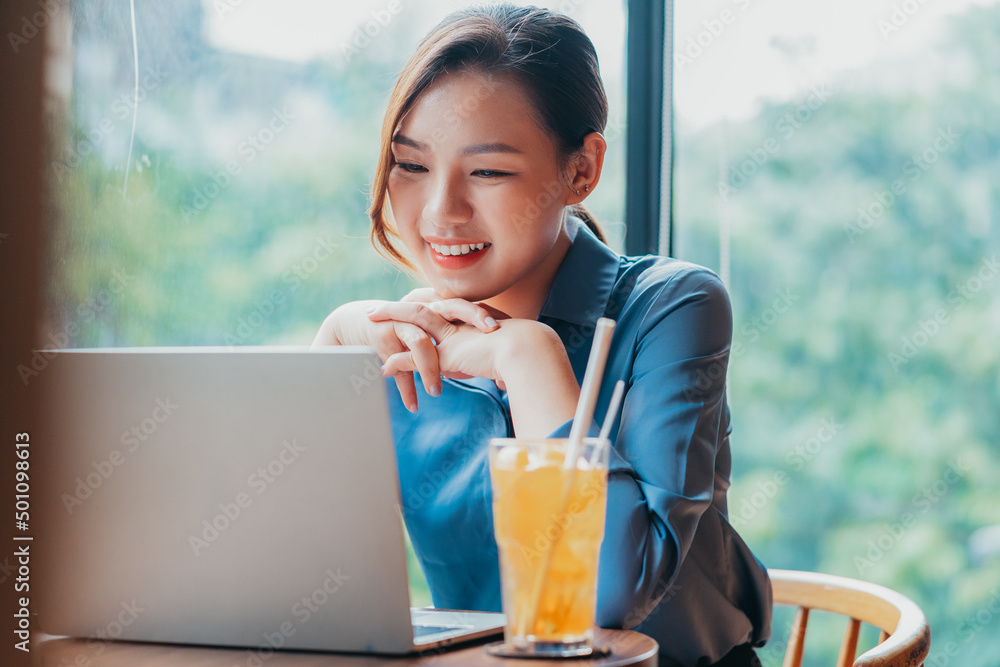 Image of young Asian businesswoman working at coffee shop