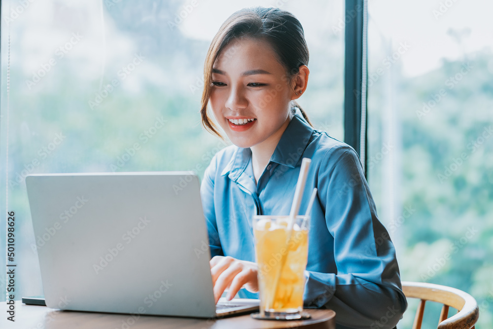 Image of young Asian businesswoman working at coffee shop