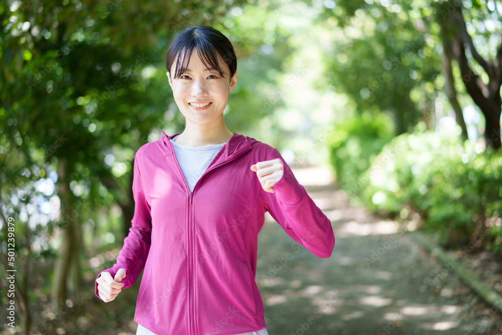 公園でジョギングをする女性