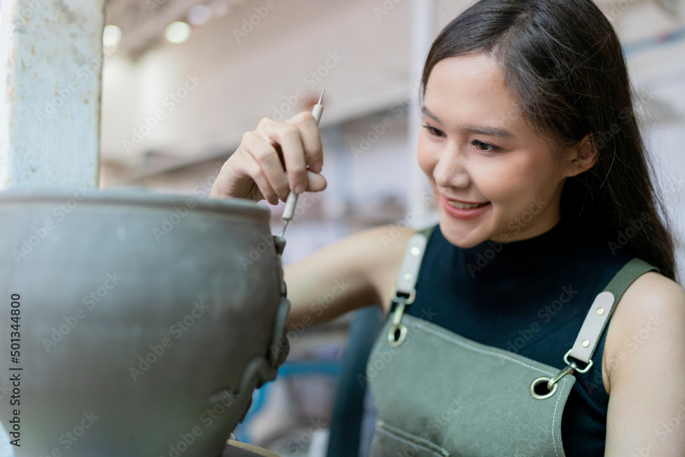 在陶轮上工作的女性双手特写，亚洲女性雕塑女性为小花瓶上色b