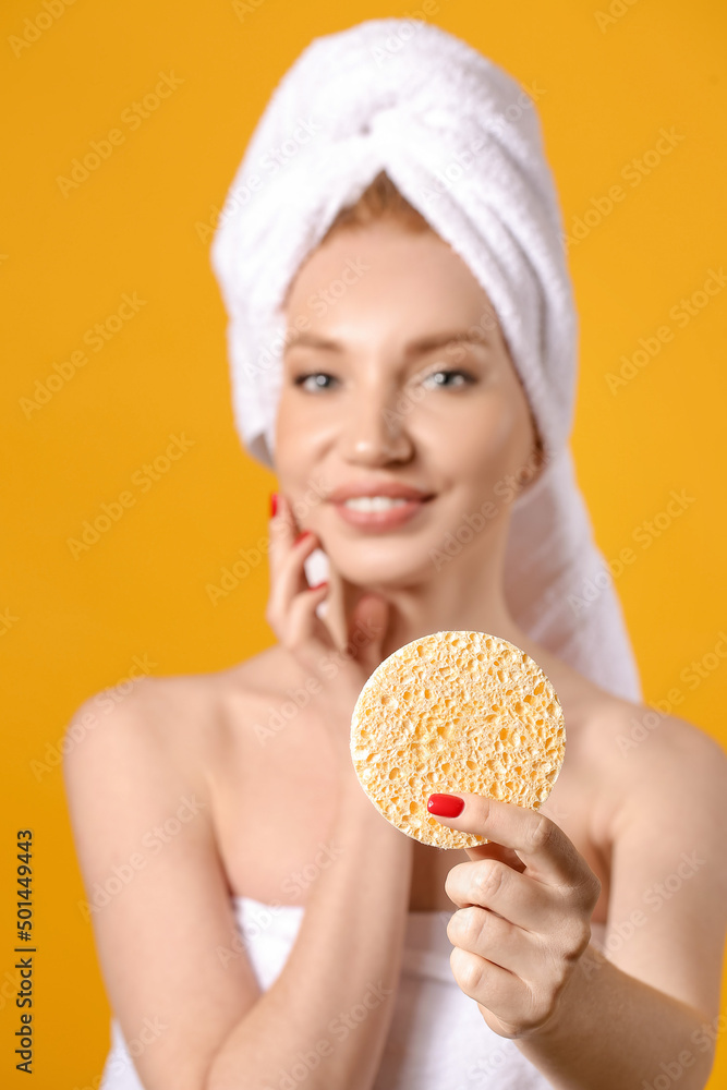 Beautiful woman with makeup sponge on color background