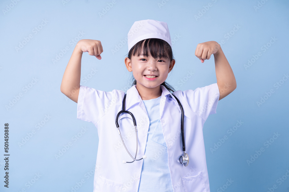 Image of Asian child wearing doctor uniform on blue background