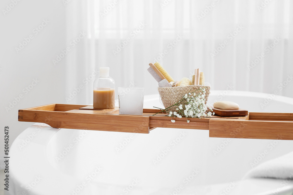 Bathtub tray with different supplies and gypsophila flowers