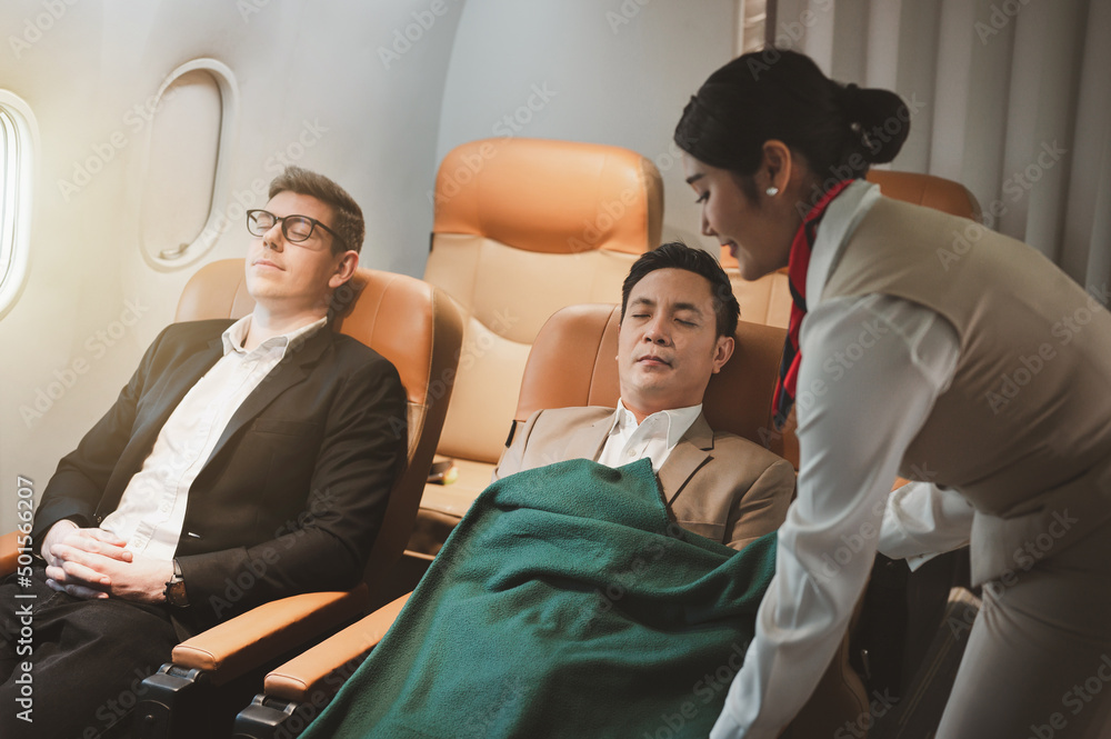 Air hostess caring for sleeping passengers on the plane