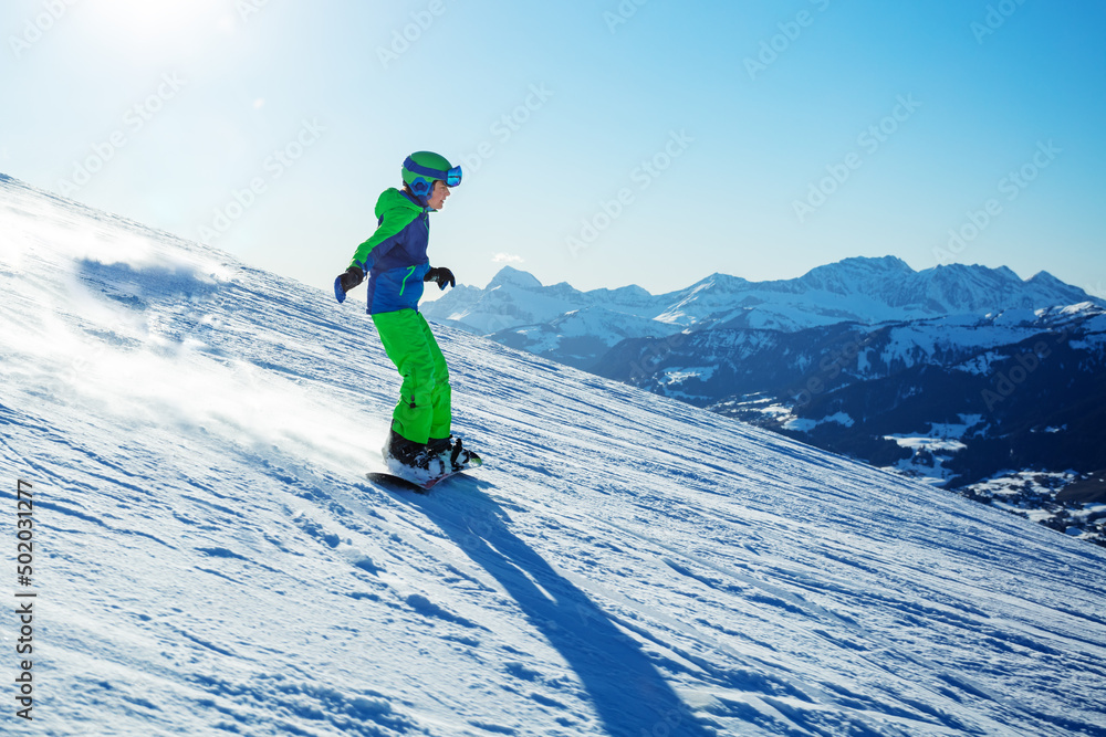 单板滑雪男孩下山的侧视图