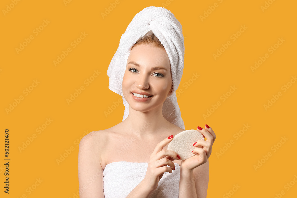 Beautiful woman with makeup sponge on color background